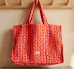 Sac cœur love pop rouge et rose maison Augustin Suspendu sur porte manteau en bois devant un mur beige 